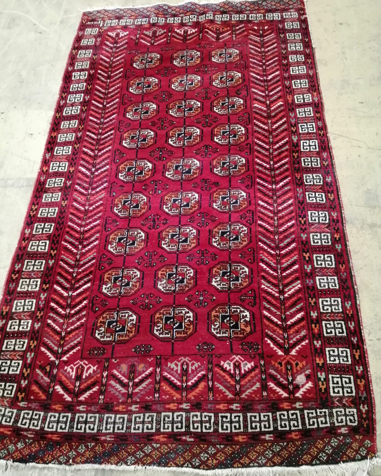 A Bokhara red ground rug, 202 x 116cm